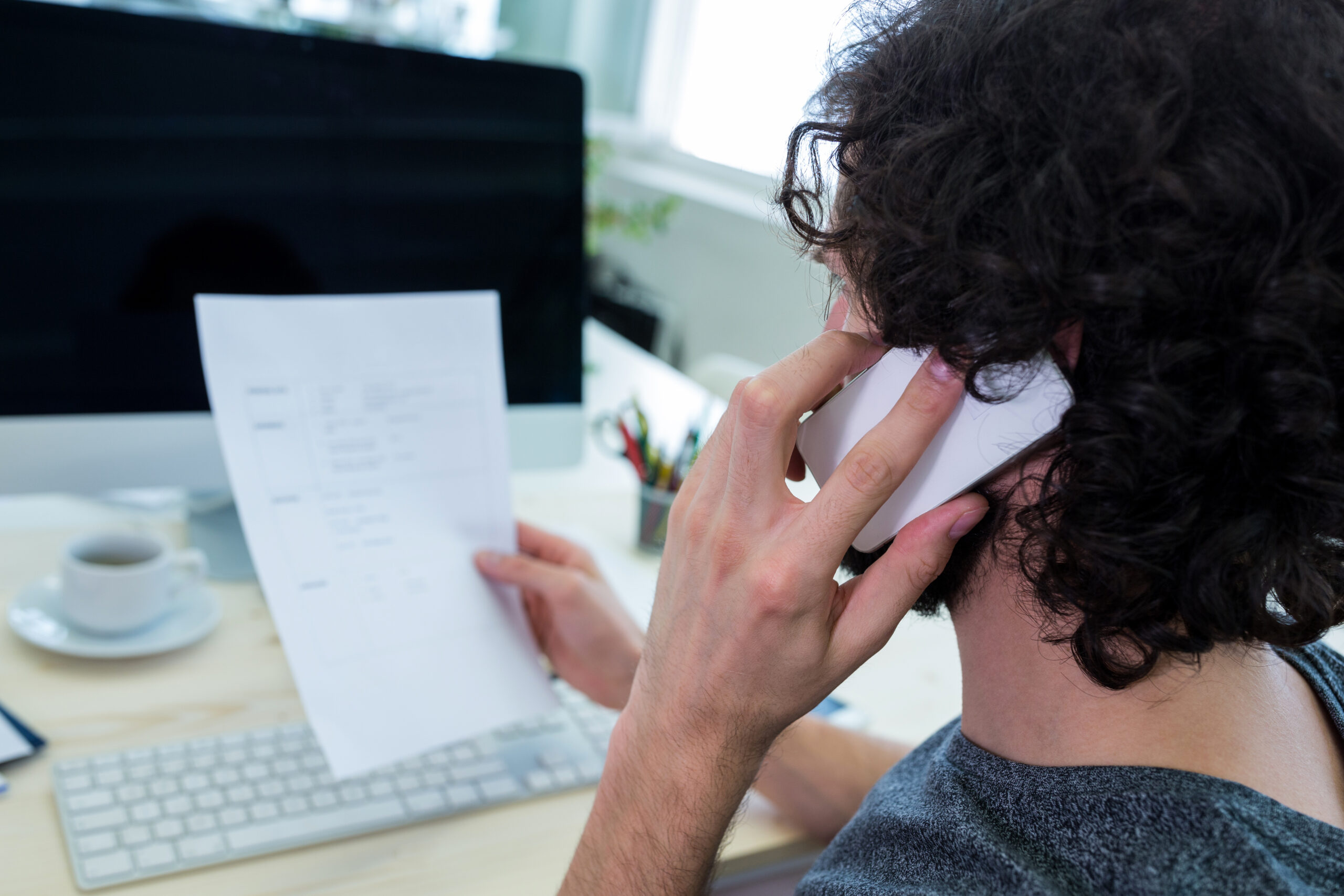 Business owner reviewing an unpaid customer invoice and payment records for debt recovery in Australia.