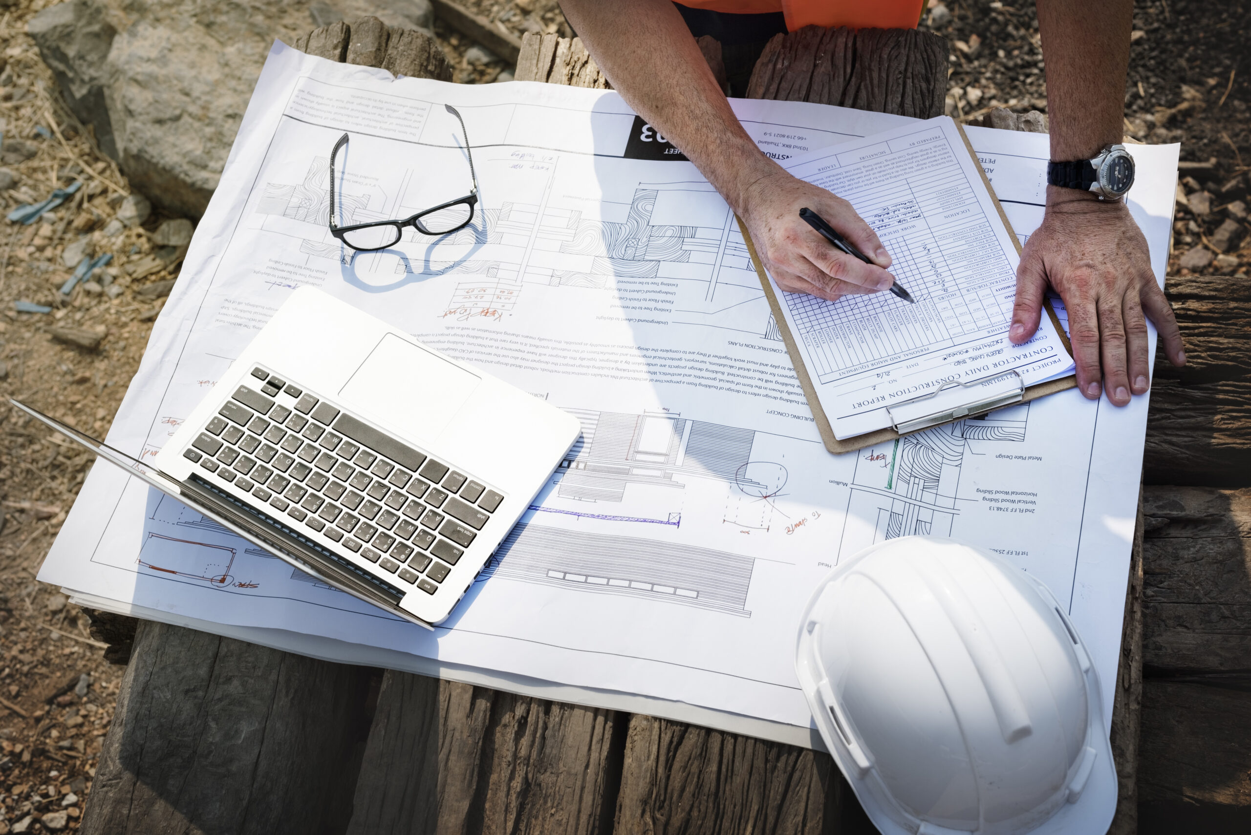 Builder reviewing unpaid construction invoices and outstanding payments to recover debts from clients and contractors in Perth, Australia.